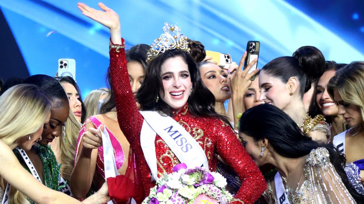Fatima Bosch raising her hand in joy after being crowned Miss Universe 2025, surrounded by contestants celebrating on stage.