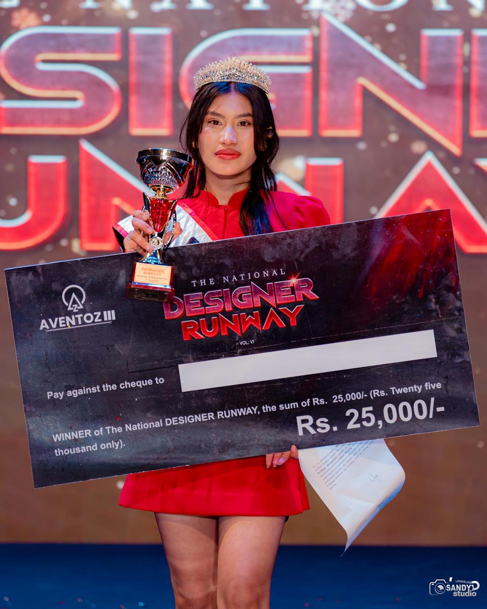 Aakriti Shrestha winner of National Designers Runway 2026 holding trophy and prize cheque on stage in Kathmandu.